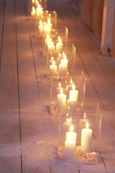 many lit candles are lined up on the ground