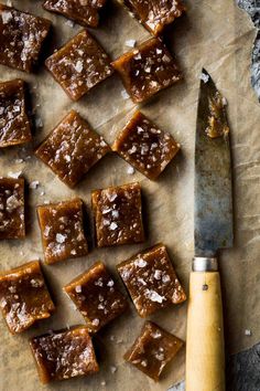 pieces of caramel brownies on a cutting board next to a knife