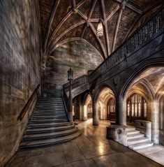 an old building with some stairs and lights in the ceiling, along with stone walls