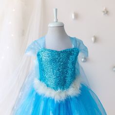 ✨ Unleash the magic of winter wonder with the enchanting Elsa Inspired Costume, perfect for any little princess dreaming of adventure in a Frozen fairytale. This floor-length blue dress is a masterpiece of craftsmanship, featuring  materials and details that will make your child's birthday or any festive occasion truly unforgettable. 👗 Dress Details: 🌀 Sequin Bodice - Glimmering sequins that catch the light, creating an icy sparkle fitting for any Snow Queen. ❄️ Snowflake Tulle Overlay - snowf