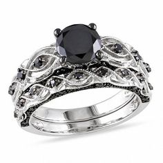 On the day you ask for her hand in marriage, express your love with this bold and elegant black diamond bridal set. Crafted in 10K white gold, the engagement ring features a 1 ct. black diamond center stone. The ring's shank features sculpted and milgrain detailing and additional black diamond accents, while additional black diamonds set at the top and bottom of the shank ensure sparkle from every angle. On your wedding day, the coordinating black diamond wedding band completes the ensemble. Rad Black Gold Ring Women, Swirl Engagement Ring Set, Black Diamond Bridal Set, Swirl Engagement Rings, Black Diamond Wedding Rings, Black Diamond Wedding Bands, Gothic Engagement Ring, Infinity Engagement Ring, White Gold Bridal Set