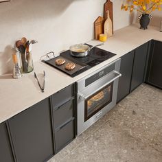 a stove top oven sitting inside of a kitchen next to a counter with utensils