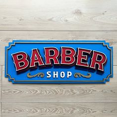 a blue sign that says barber shop on the side of a wooden wall with wood planks