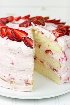 a cake with white frosting and strawberries is cut in half to show the inside