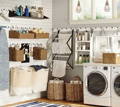 a washer and dryer in a room with baskets on the wall next to it