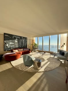 a living room filled with furniture and large windows overlooking the ocean on a sunny day