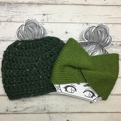 two knitted hats with green bows on top of each other, one has an ear flap and the other has a bow tie