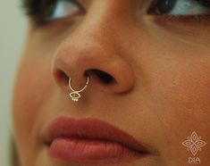 a close up of a person with a nose ring on their nose and one eye open