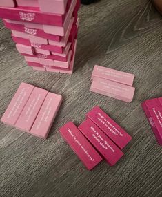 several pieces of pink paper sitting next to each other on a wooden table with words written on them