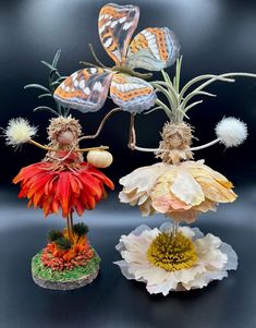 two figurines with flowers and butterflies on them