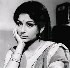 an old photo of a woman with her hand on her face and looking at the camera