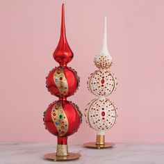 two red and white vases sitting next to each other on top of a table