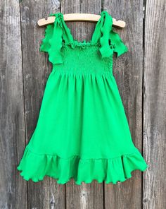 Green Smocked Dress This cute custom boutique green smocked dress would be perfect for St. Patricks Day or just a fun day out in the sun. Dress is a soft green knit, smocked, with shoulder ties to keep fitted. Your baby girl is guaranteed tons of compliments in this cute little dress. 100% Cotton St. Patricks Day Theme Wash Warm tumble dry low iron if needed Made To Order MADE IN USA Green Ruffled Straps Sundress For Summer, Green Sundress With Ruffled Straps For Summer, Cute Smocked Dress With Ruffles For Spring, Cute Spring Smocked Dress With Ruffles, Green Ruffled Sundress For Garden Party, Cute Smocked Dress With Ruffle Hem For Summer, Cute Smocked Summer Dress With Ruffle Hem, Cute Summer Smocked Dress With Ruffle Hem, Green Ruffled Straps Sundress For Spring