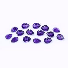 purple ametholite gems are arranged on a white surface