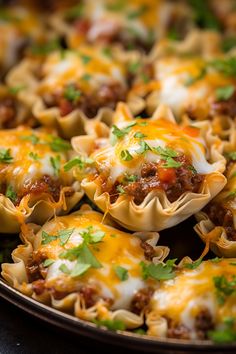 some taco shells with meat and cheese on them are ready to be served in the oven