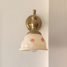 a light that is on the wall next to a white wall with wood paneling