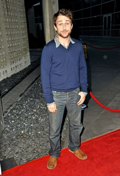 a man standing on top of a red carpet