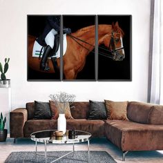 a living room with a couch and two paintings on the wall showing a woman riding a horse