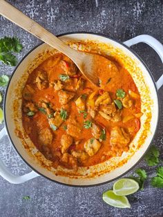 a pan filled with chicken curry and garnished with cilantro