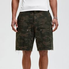 The Frayed Double-Knee Camo Cargo Shorts masterfully blend military elements with street style. These slightly oversized shorts feature an all-over camouflage print and a durable double-knee design for added toughness. The frayed hem adds an edgy touch, while the back pocket is adorned with a metal logo badge for a distinctive look. Crafted from premium 100% cotton fabric (370g/m²), these shorts ensure both comfort and durability, making them perfect for any urban adventure. All-over camouflage Urban Camouflage Bottoms Relaxed Fit, Combat Cargo Style Bottoms For Summer, Summer Combat Cargo Bottoms, Summer Combat Cargo Style Bottoms, Spring Camouflage Bottoms For Streetwear, Combat Style Bottoms For Summer Streetwear, Utility Knee-length Shorts For Streetwear, Summer Combat Cotton Bottoms, Military Camouflage Cotton Shorts