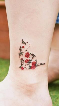 a woman's foot with roses on it and a cat in the middle of her leg