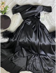 a black dress is laying on a bed