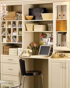 a white desk with a laptop computer on top of it next to a book shelf