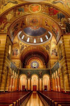 the inside of a church with many pews and stained glass windows on the ceiling