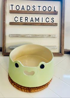 a dog bowl with the words toadstool ceramics in front of it on a tile floor