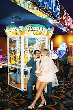 a man and woman sitting in front of a game machine