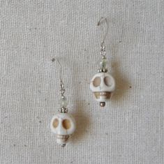 "White magnesite stone skull beads are wire wrapped and linked with silver daisy beads, seed beads and clear crystal bi cone beads on silver plate ear wires. Add a touch of the macabre for Halloween delight or enjoy for a year round Gothic look. The length of these earrings is a 7/8 \" dangle from silver plate on brass ear wires and the width of the skull bead is 3/8\". All of my jewelry items come boxed and lace ribbon tied and tagged for easy gifting. These earrings are ready to ship." Daisy Beads, Skull Beads, Earrings Gothic, Earring Storage, Fabric Earrings, Earring Organizer, Eyeglass Holder, Beaded Skull, Skull Earrings