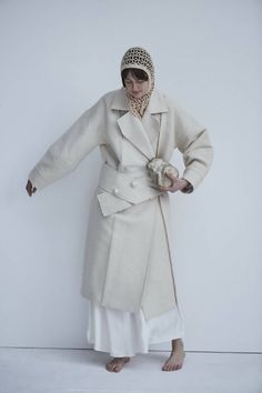 This sweeping statement coat exudes oversized elegance with its wide lapels leading to a romantic deep V neckline. Falling just above the ankles, the Snegurochka Cream Wool Hemp Shell Buttons Coat is both cozy and sophisticated. Made from a blend of durable hemp and wool fibers, its sturdy structure is punctuated with uniquely handcrafted ceramic shell buttons. Lined.Composition 40% Hemp 60% Wool and it´s undyed.Lining 100% viscoseTrimming 100% ceramic glazed handmade shell buttonsSizesOversize. Elegant Oversized Beige Wool Coat, Chic Long Pea Coat For Fall, Single Breasted Shawl Collar Outerwear For Spring, Long Sleeve Double-breasted Wool Coat For Spring, Spring Single Breasted Shawl Collar Outerwear, Elegant Spring Wool Coat With Double-breasted Buttons, Oversized Beige Shawl Collar Outerwear, Elegant Oversized Wool Coat, Chic Winter White Wool Coat For Fall