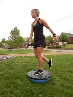 a woman standing on top of a trampoline in the grass