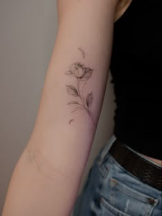 a woman's arm with a flower tattoo on the left side of her arm