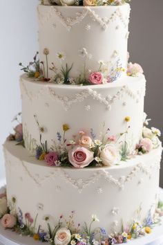 a three tiered wedding cake with flowers on it