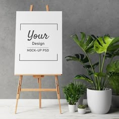 an easel next to some potted plants and a sign that says your design mockup psd