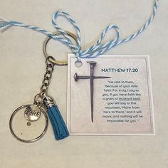 a keychain with a cross on it and a blue tassel hanging from the end