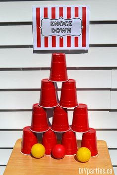 red cups stacked on top of each other in front of a sign that says knock down