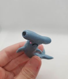 a hand holding a tiny blue toy animal