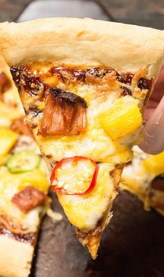 a slice of pizza is being held up to the camera