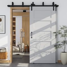 a living room with white walls and wooden floors, an open sliding door leading to the bedroom