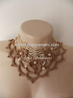 a mannequin with an elaborate necklace on it's neck, and pearls