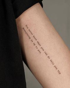 a woman's arm with a quote written on the back of her left arm