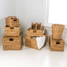 four wicker baskets stacked on top of each other in front of a white wall