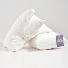 three pillows stacked on top of each other in front of a white background with a price tag