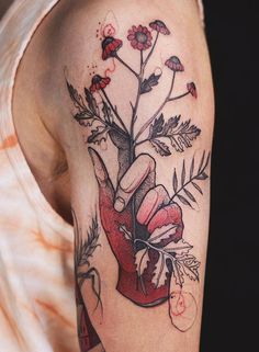 a woman's arm with flowers and a heart on it