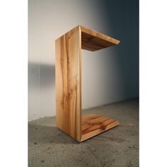 a wooden shelf sitting on top of a cement floor