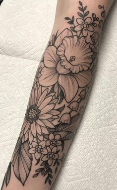 a black and white flower tattoo on the arm