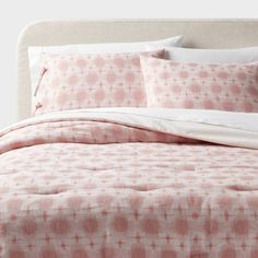 a bed covered in pink and white sheets