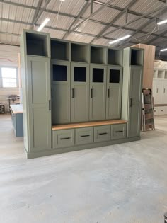 an empty storage room with several cabinets and drawers in it, all painted olive green